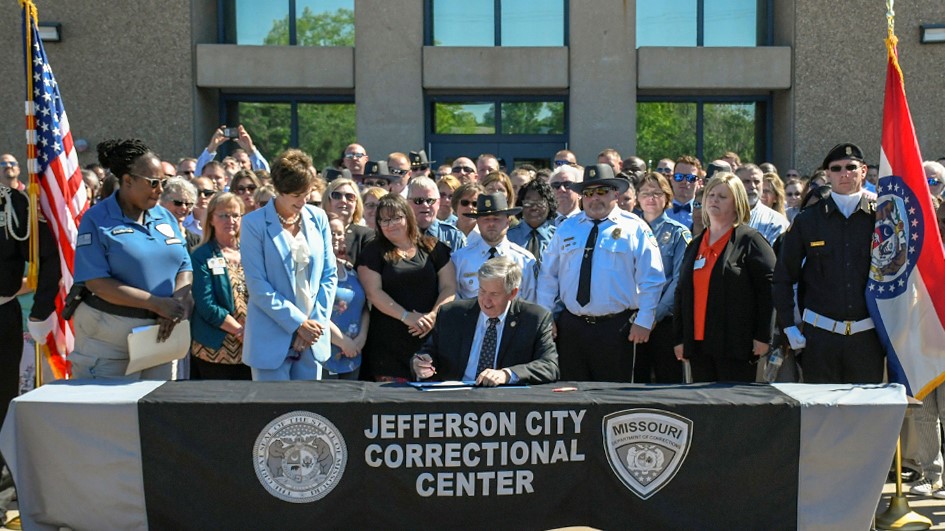 Governor Mike Parson signs the budget bill in front of Jefferson City Correctional Center