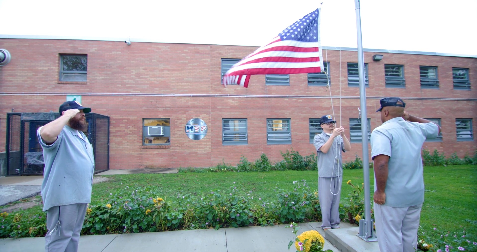 Offenders saluting a U.S. flag at Boonville Correctional Center.