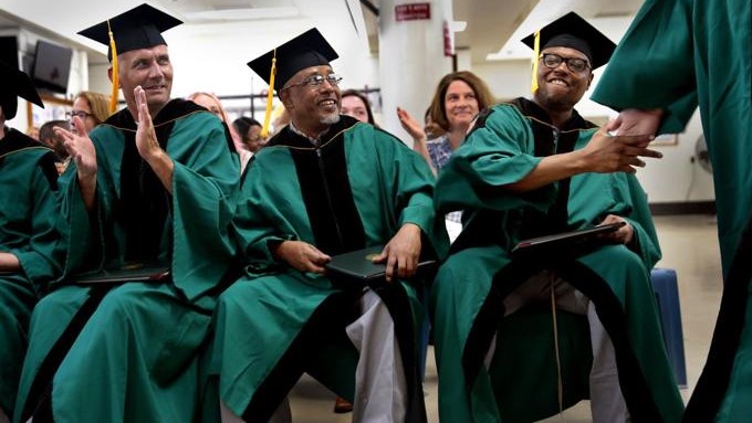 Offenders in caps and gowns attend their Washington University graduation ceremony inside a correctional center.