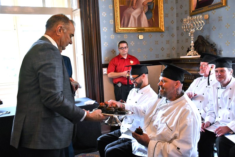 Governor Mike Kehoe serves refreshments to the graduates at the Missouri Governor's Mansion.