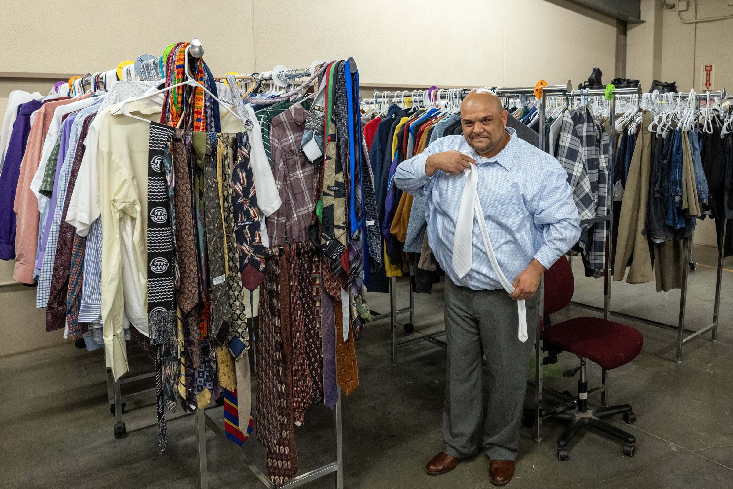 Jose Zavala shows off some of the donated clothes from TCKC’s professional attire rack that are available to residents for job interviews. Zavala, who has served five prison terms, has completed the TCKC program and now works in the food-service industry.