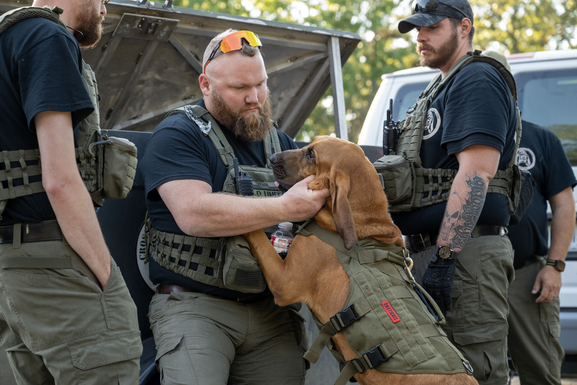 Officer scratches the ears of bloodhound