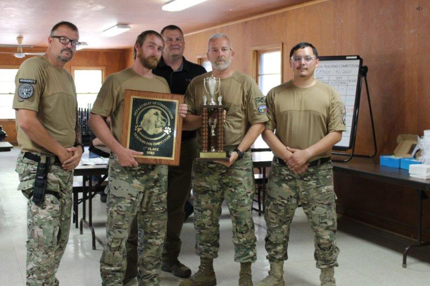 eam of correctional officers poses with first-place plaque and trophy