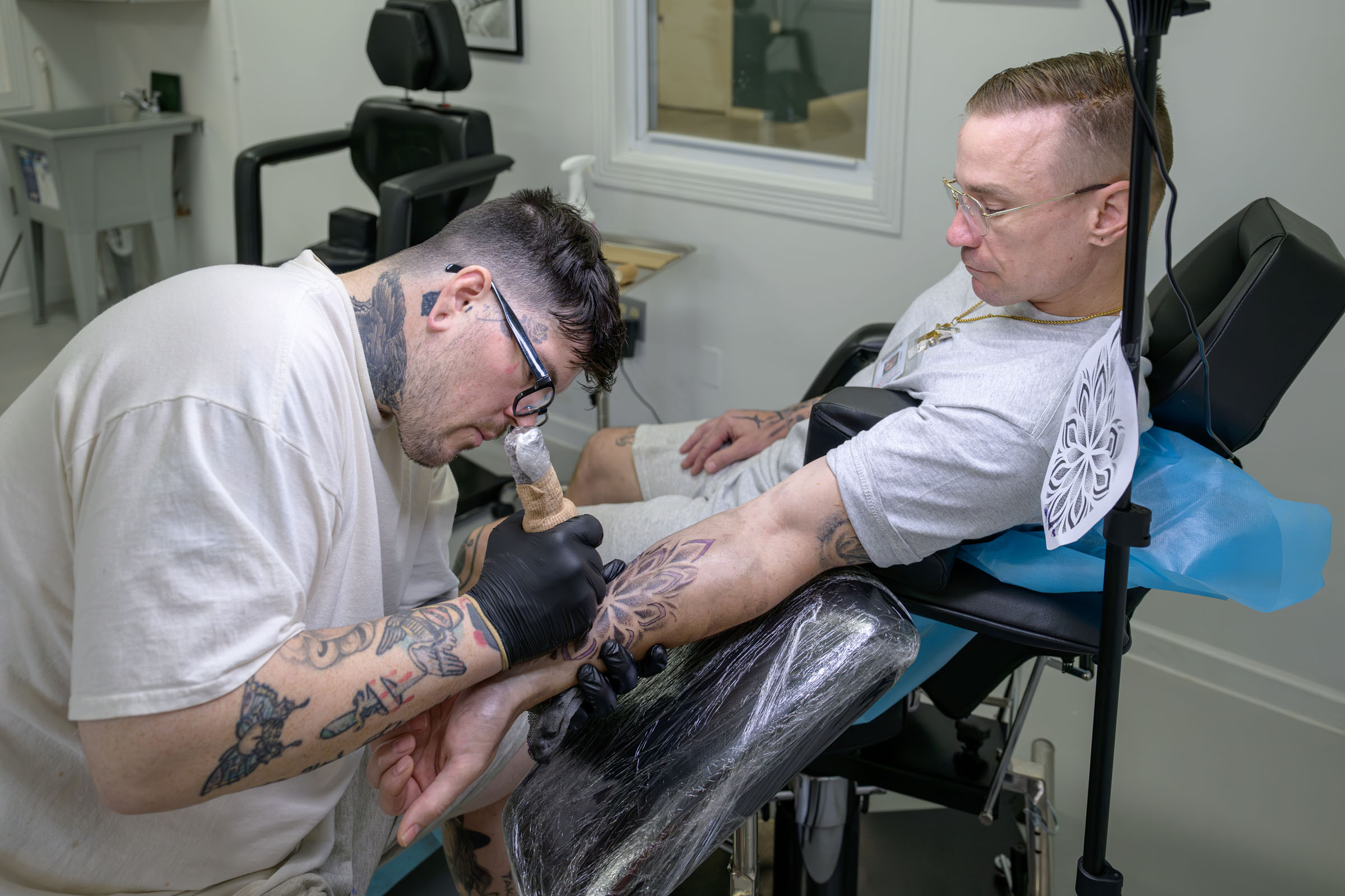 Artist uses rotary machine to tattoo his client’s arm. 