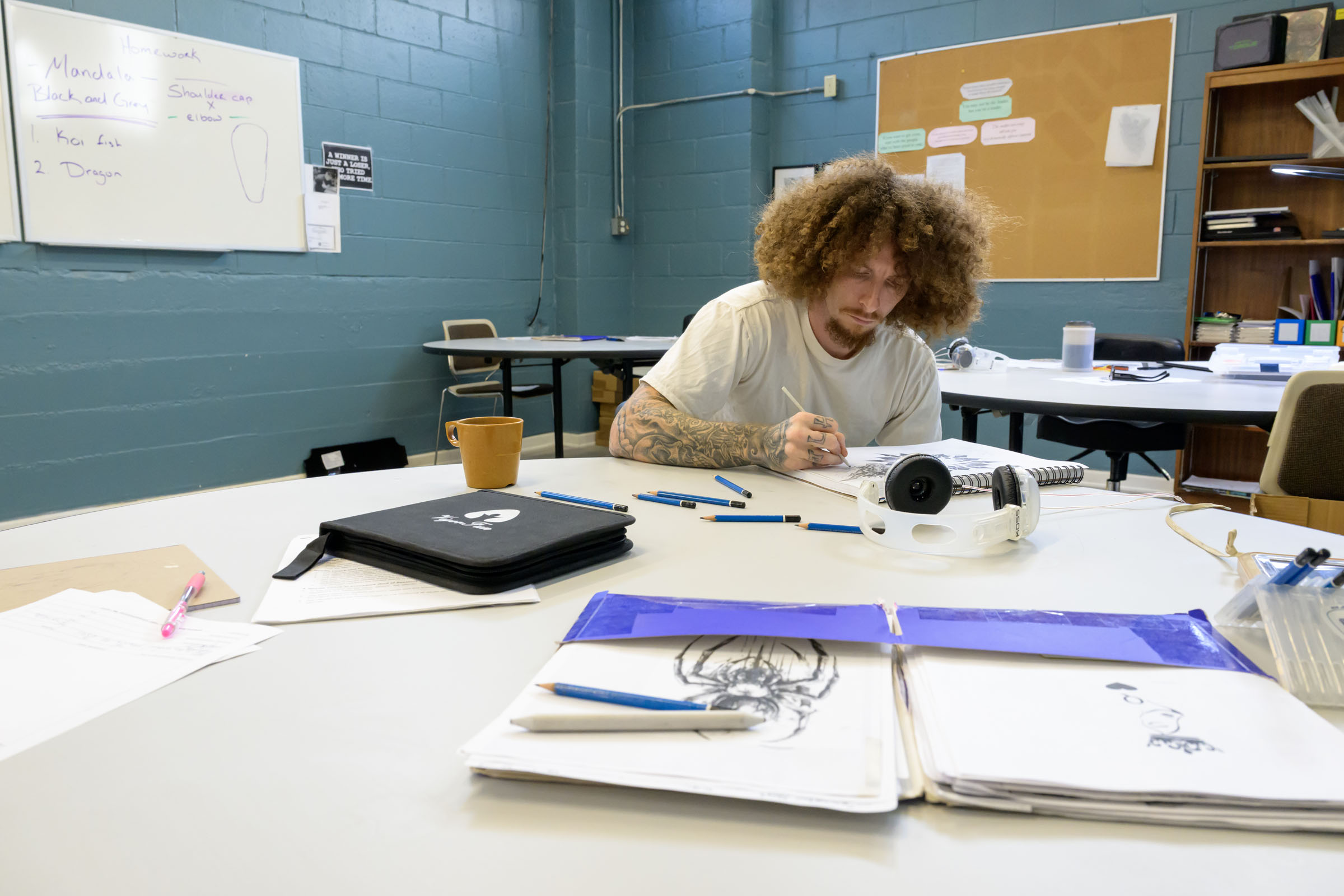 Artist sketches at a table.
