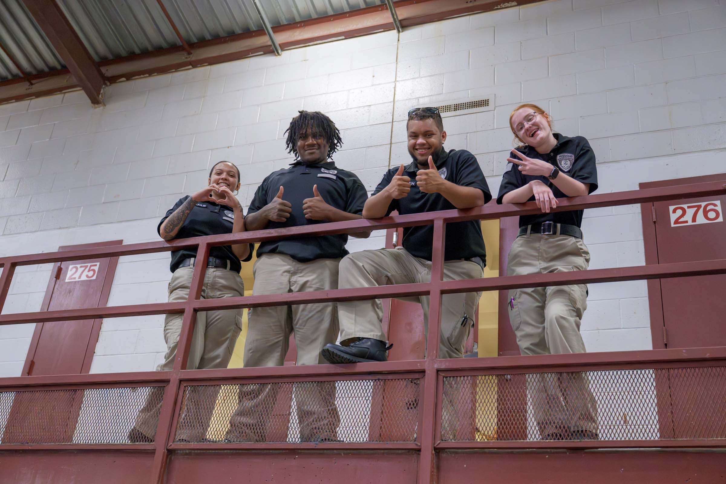 Cadets pose along a second-story rail in a housing unit.