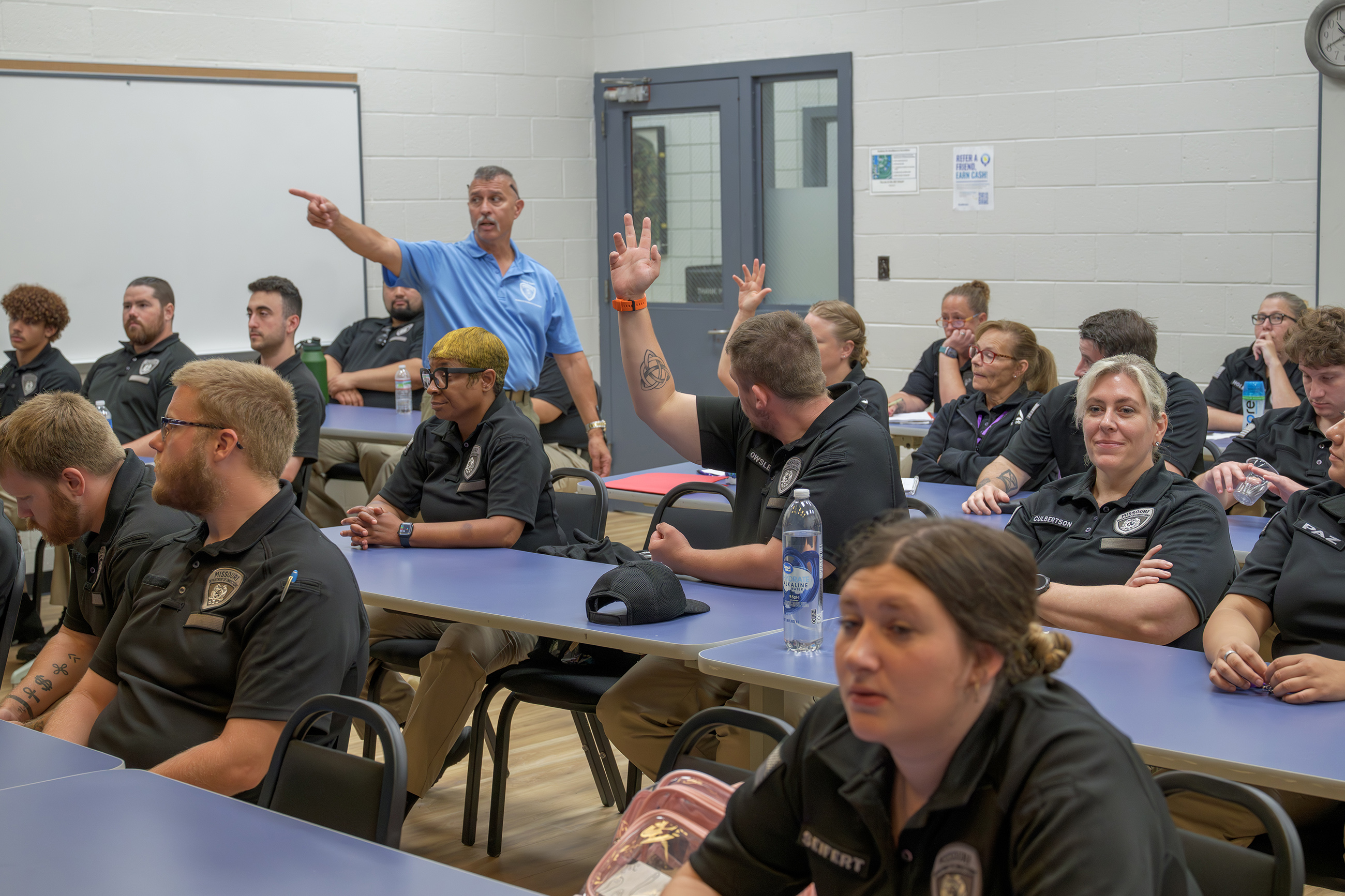  A cadet raises his hand to contribute to the class discussion.