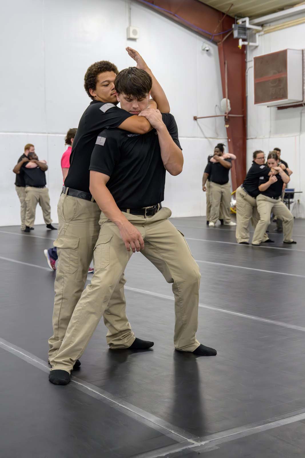Students in the AEC gymnasium practice a variety of use-of-force techniques.