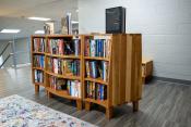Bookcase seen at three quarter view in a seating area at the top of a staircase