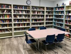 library room with books, a table and chairs