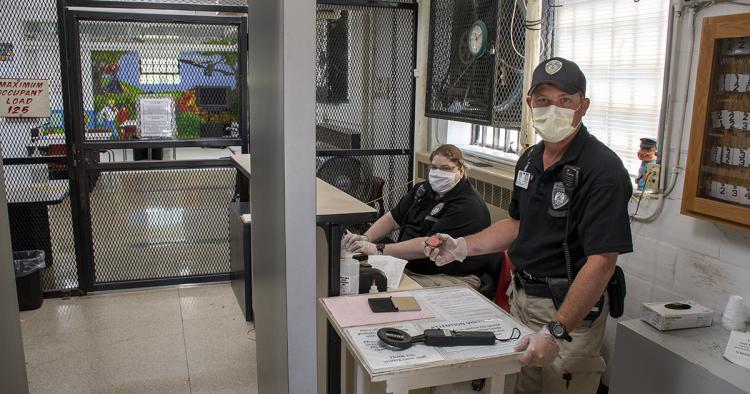Staff in masks and gloves greet visitors at the Algoa visiting room entrance.