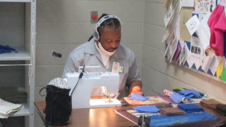 Offender William White making a quilt
