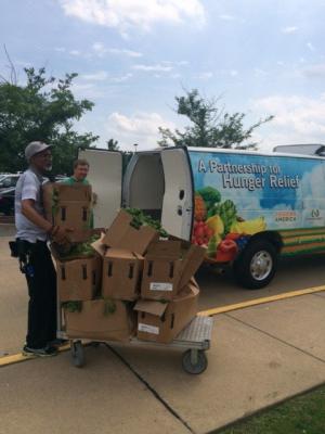 Men loading boxes of vegetables into a truck.