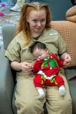 Alexis Clark holds a sleepy newborn during the holiday party.