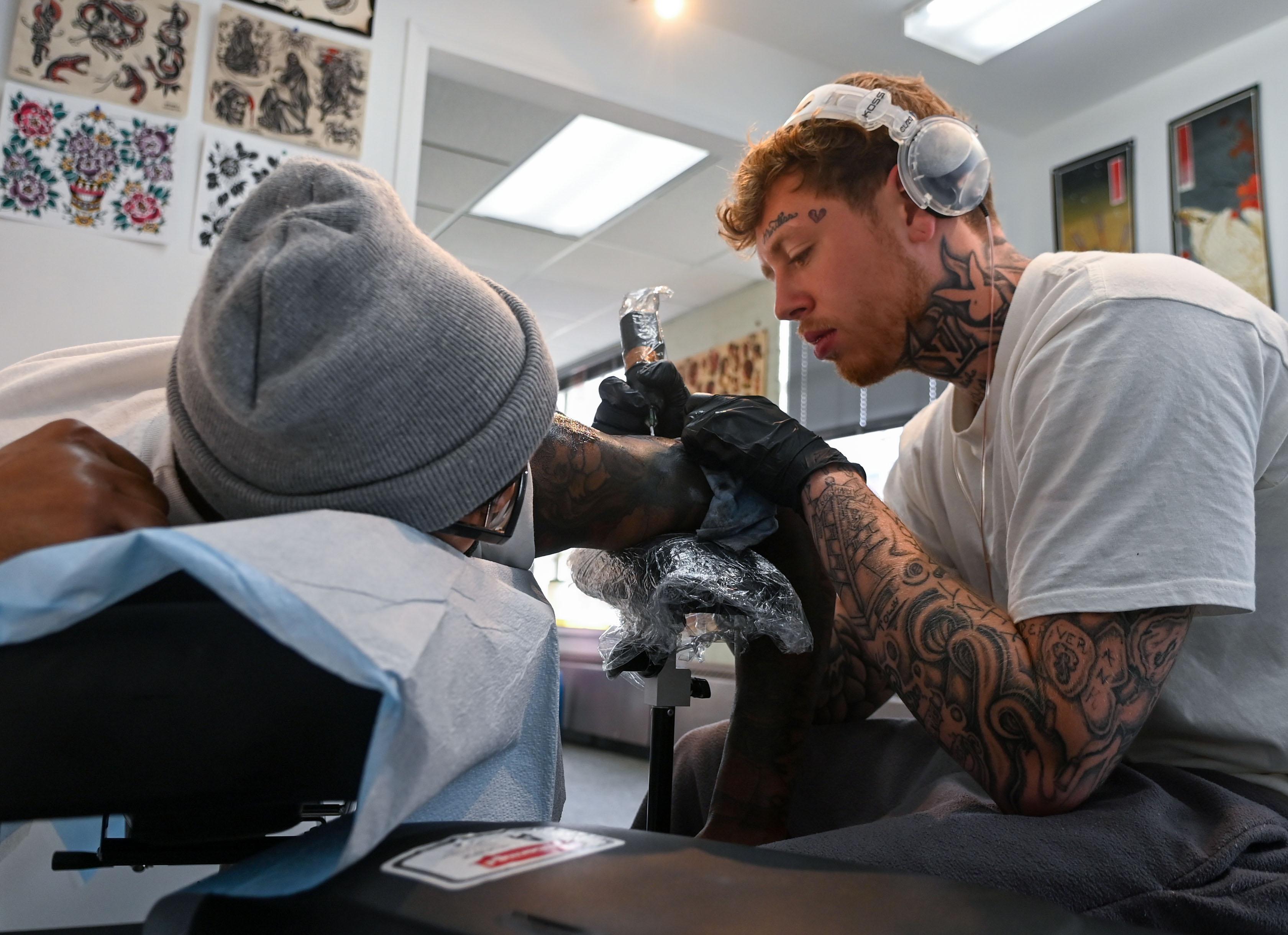 Tattoo apprentice tatooing a client