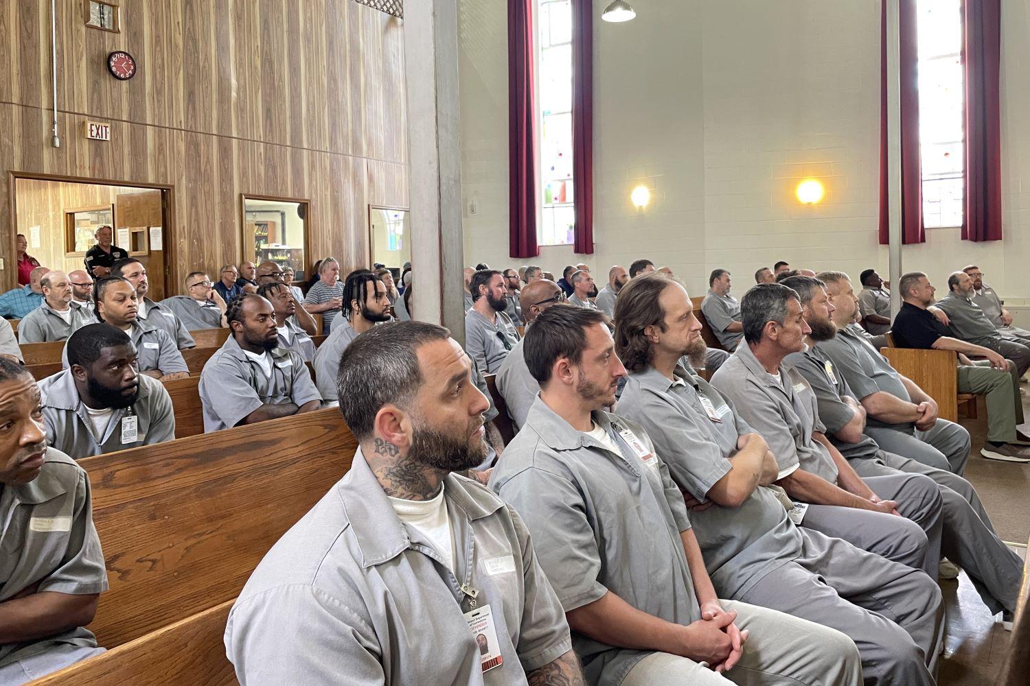 Residents listen to Kansas City Royals player Lucas Erceg speak in the chapel at Boonville Correctional Center