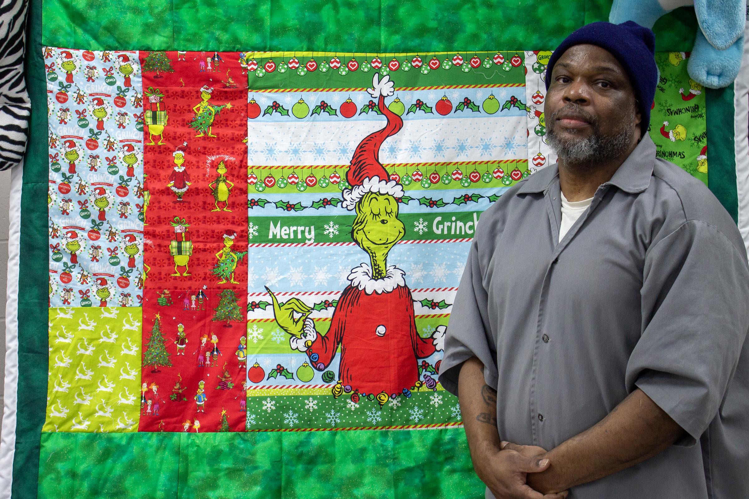 A Restorative Justice volunteer with the Grinch quilt he made