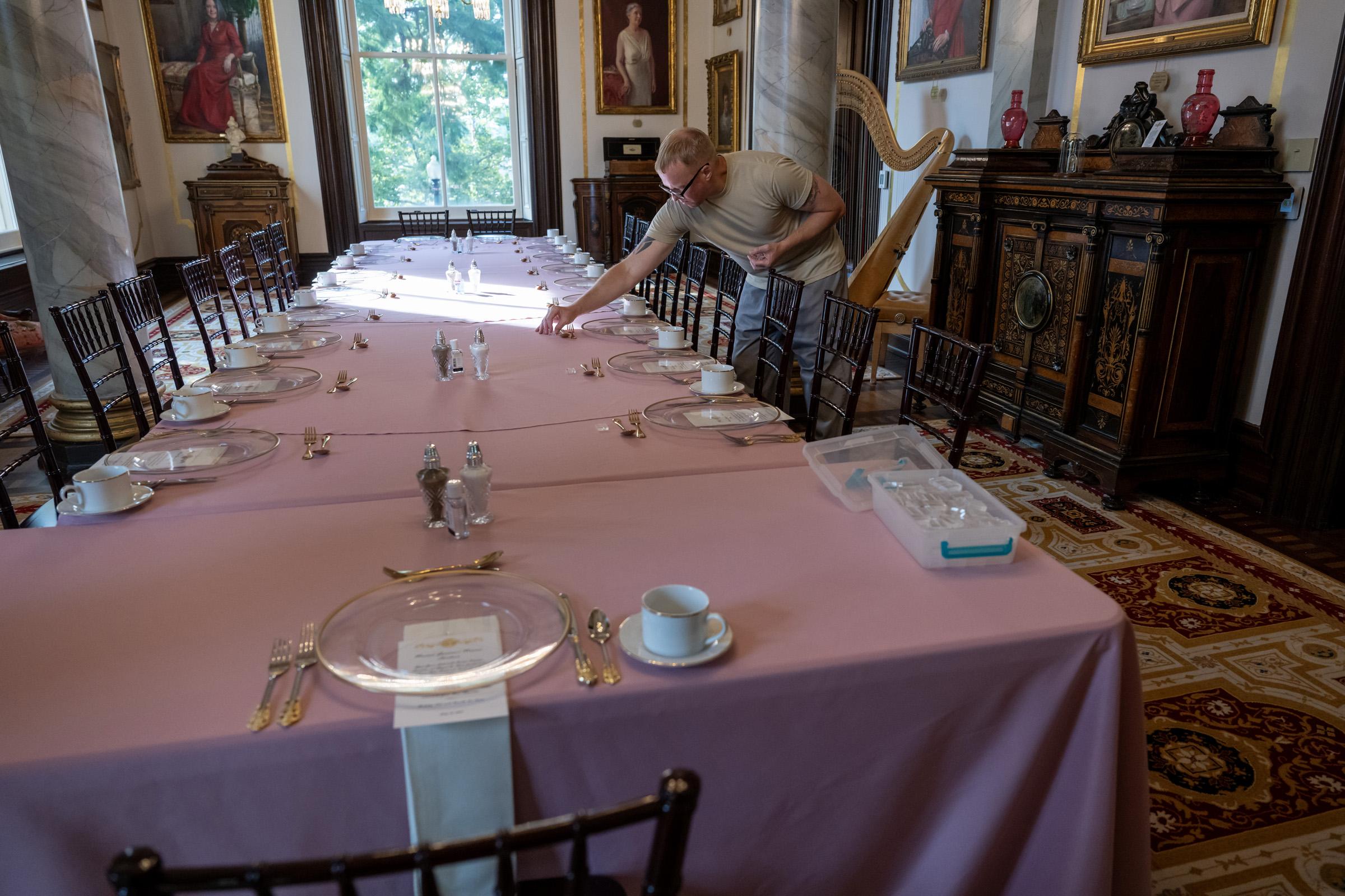 Jeremy Burton sets the table for a luncheon.