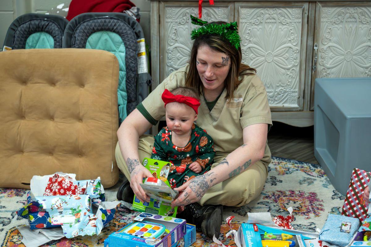 Kathy Briggs opens gifts with Lyric, one of her twins.