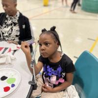 Child paints fishing lures at Southeast Correctional Center.