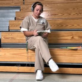 woman offender wearing headphones and using a computer tablet