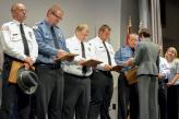 Group of corrections officers in uniform receiving awards.