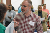 Several staff members mingling and taking notes in a workshop