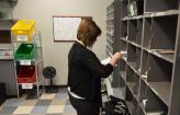 Staff member sorting mail into mailboxes.