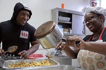 Man and woman pouring batter into a tin.