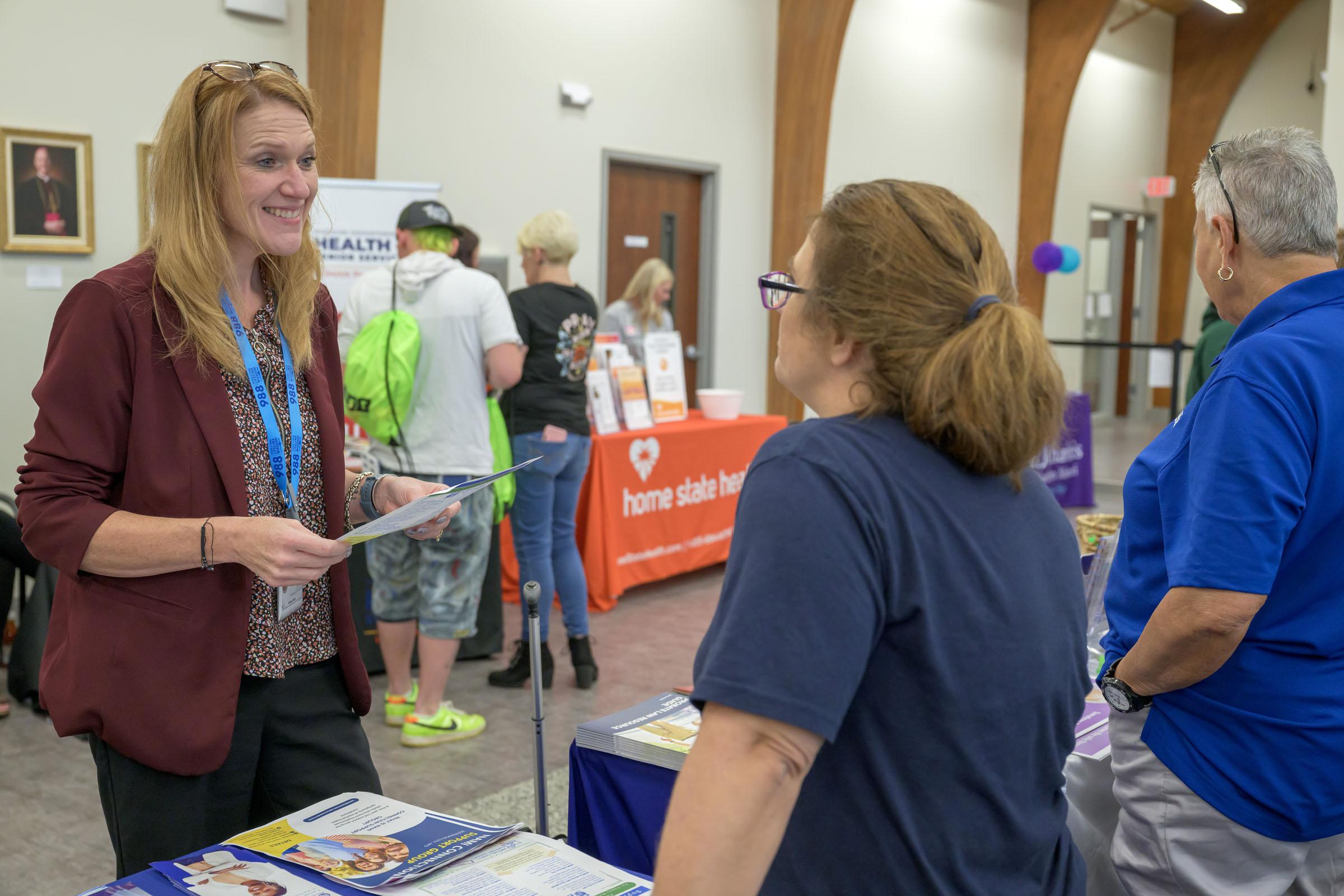 Melissa Adams talks to representatives at a resource fair.